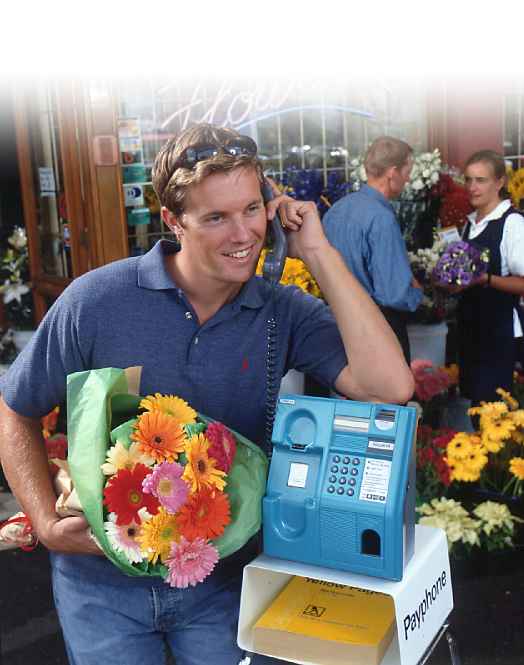 A Diamond Payphone in a florist's shop, with guy explaining why he will be late.